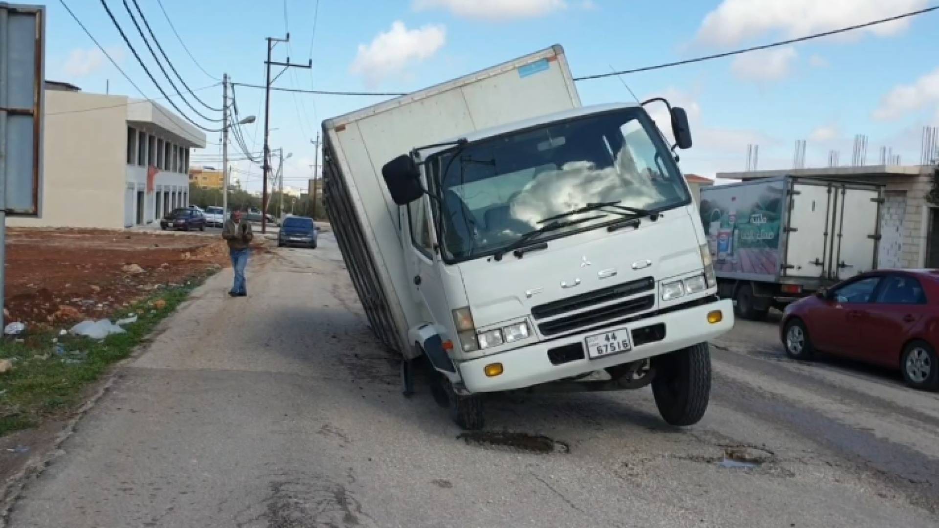 شاحنة عالقة في حفرة بشارع بشرى