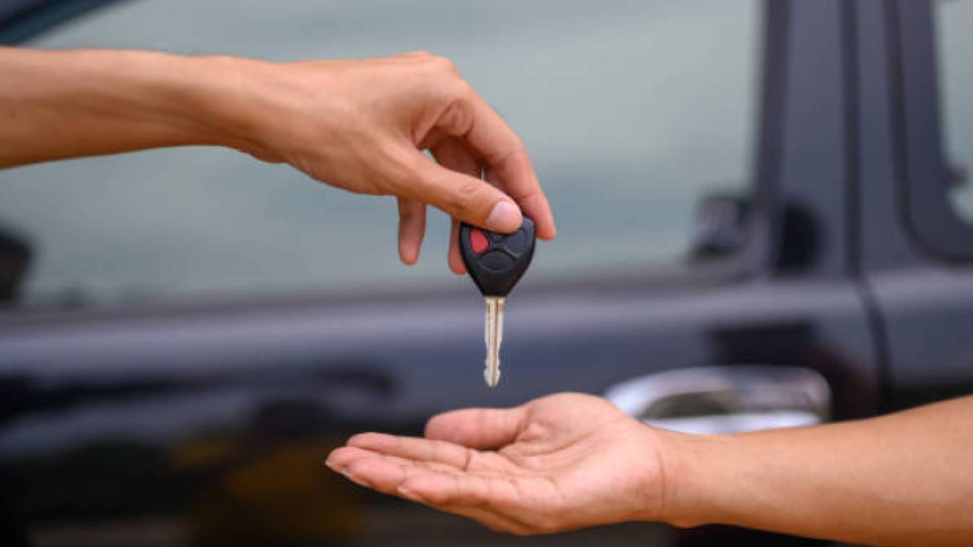 صورة تعبيرية لشخص يحمل مفتاح مركبةأ