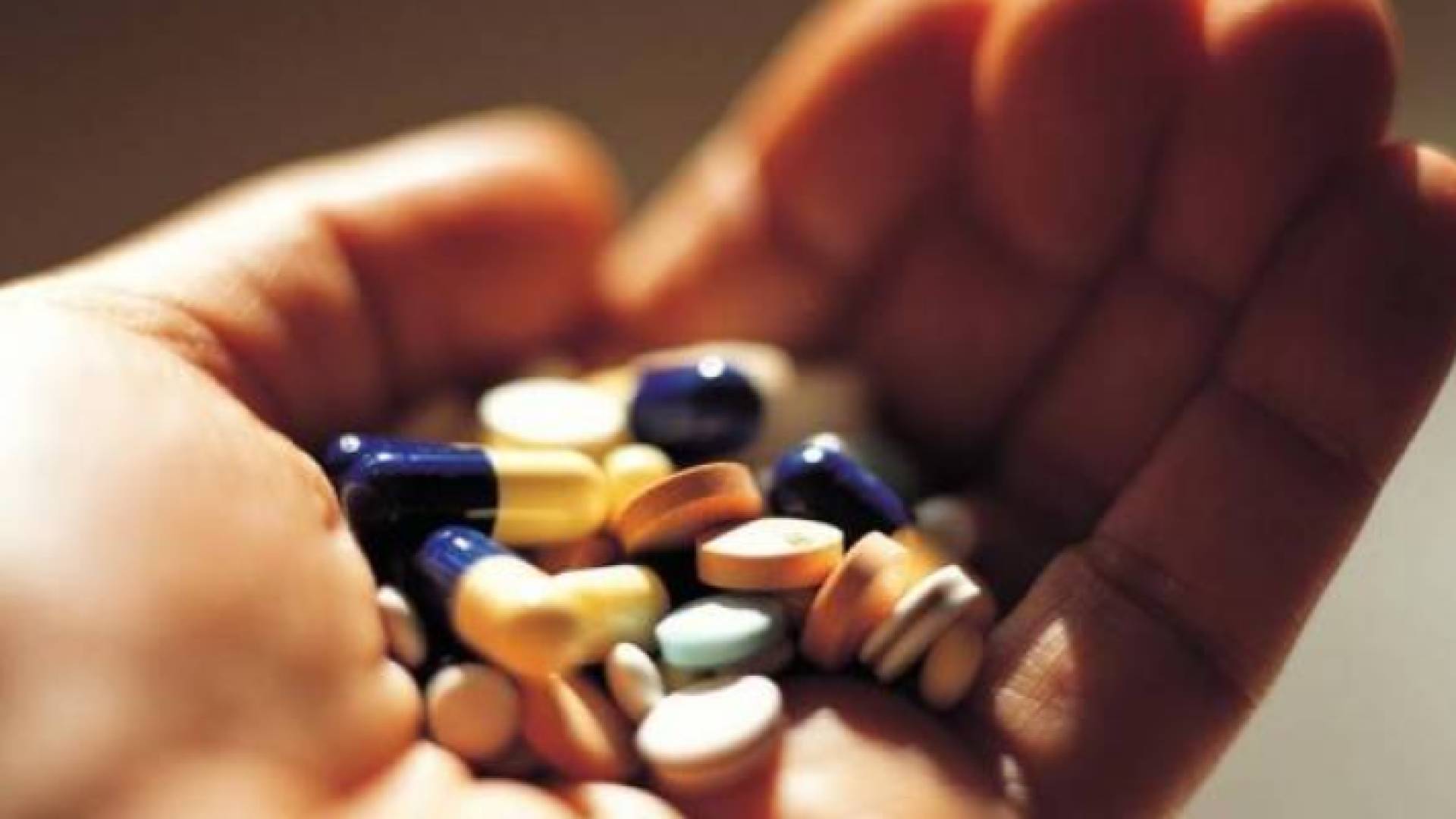 صورة تعبيرية لفتاة تحمل كمية من الأدوية