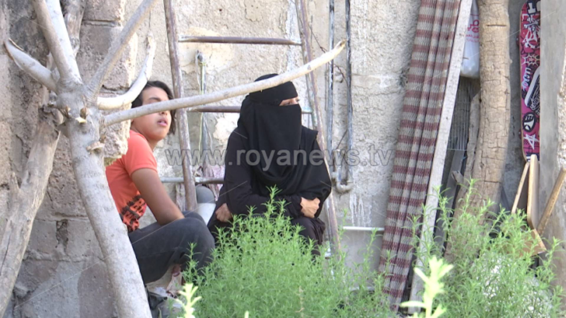 أم سند وابنها أمام منزلها المتهالك