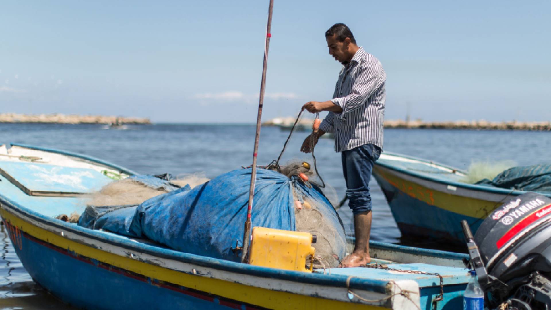 فلسطيني يعمل في قارب صيد في بحر غزة