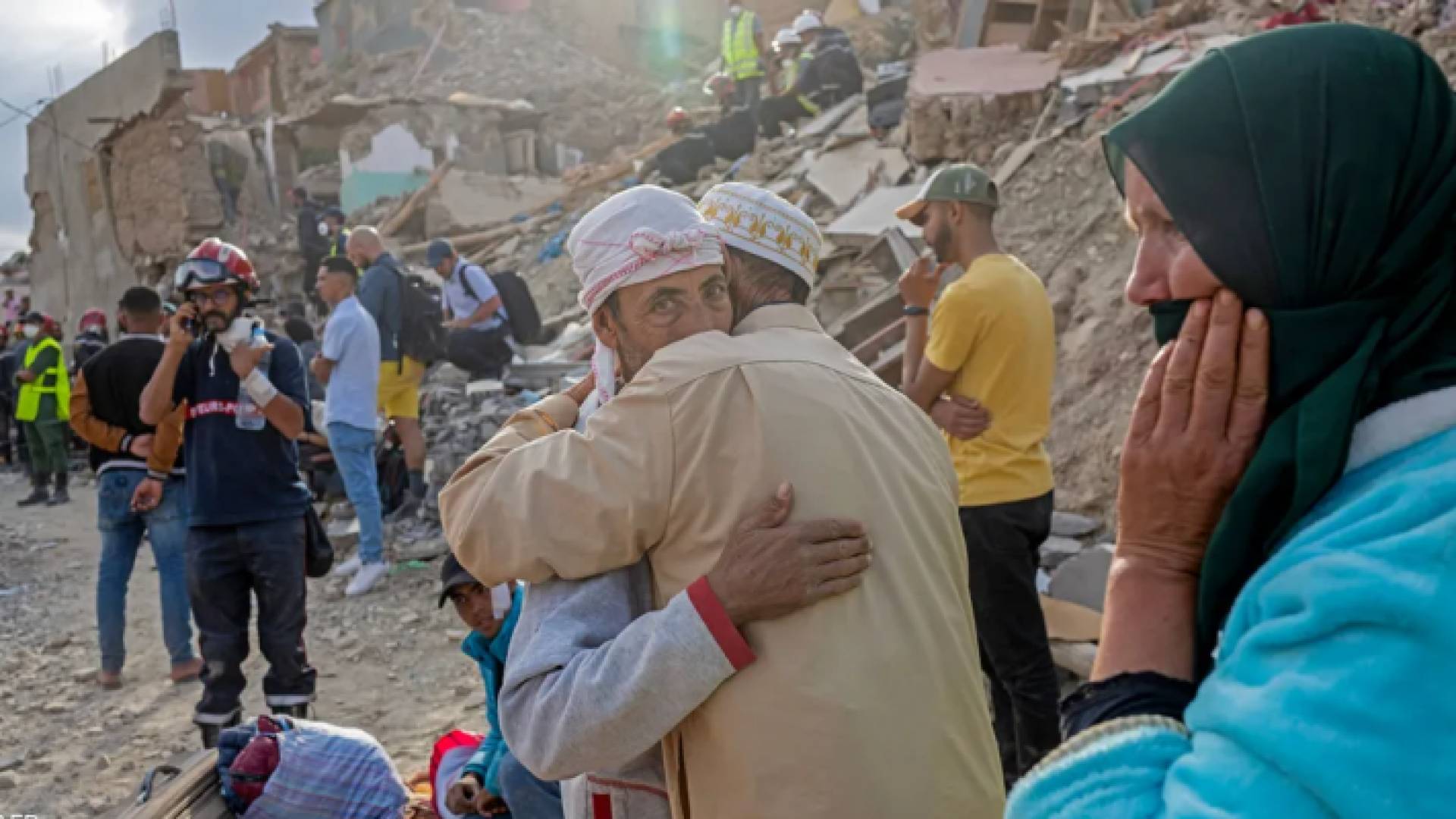 مغاربة يقفون أمام منازلهم التي دمرها الزلزال