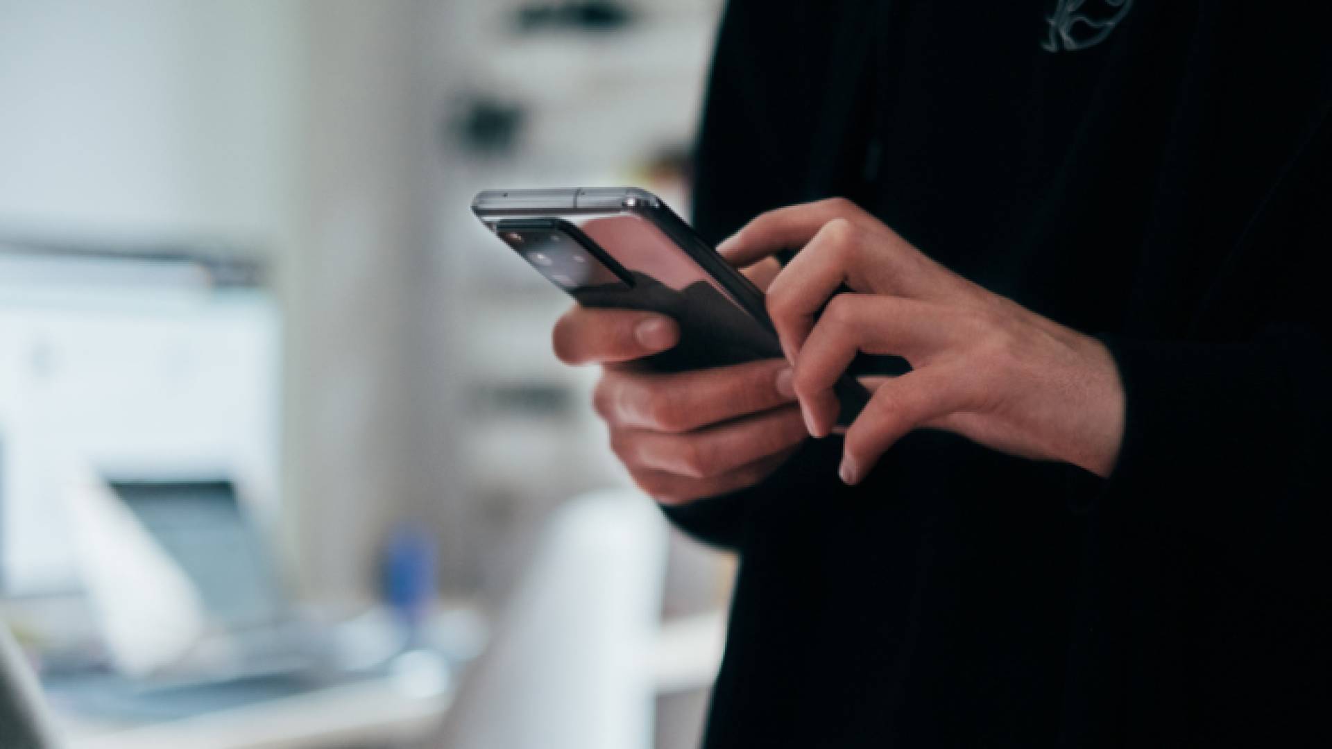 شخص يحمل هاتف خلوي