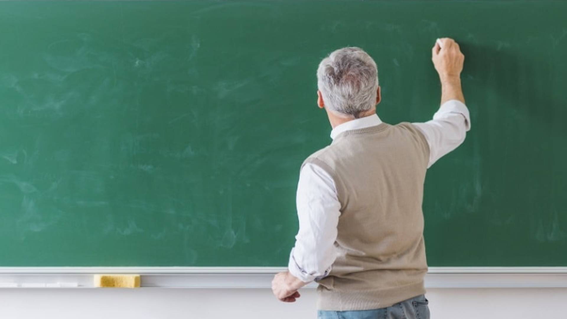 صورة تعبيرية لمعلم يكتب على السبورة