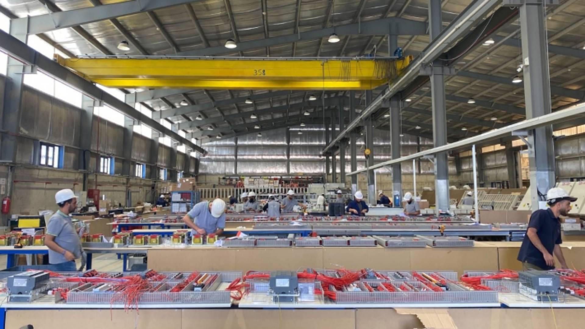 عمال في خط إنتاج لوحات تجميع القطع الكهربائية