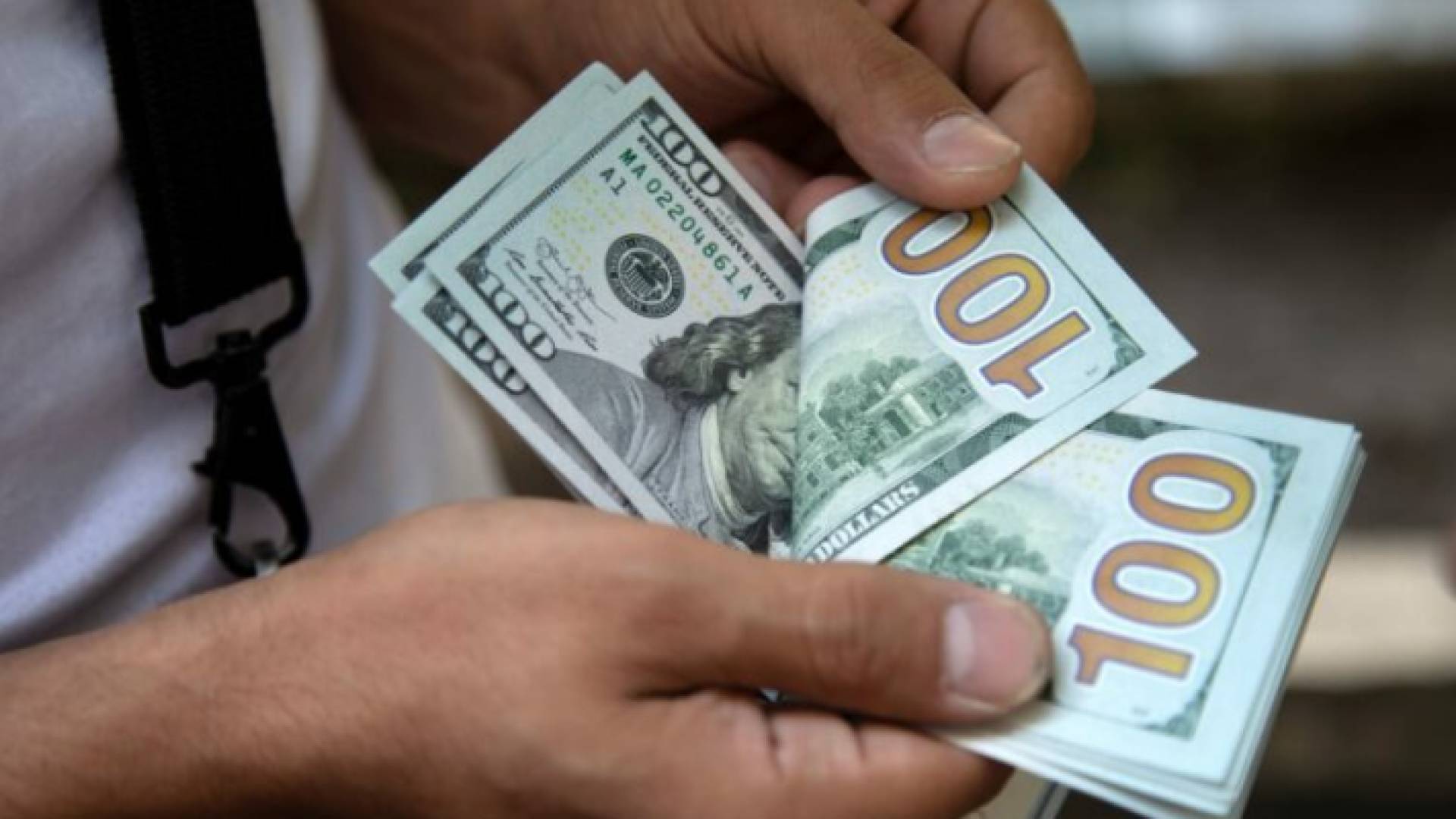 شخص يحمل دولارات