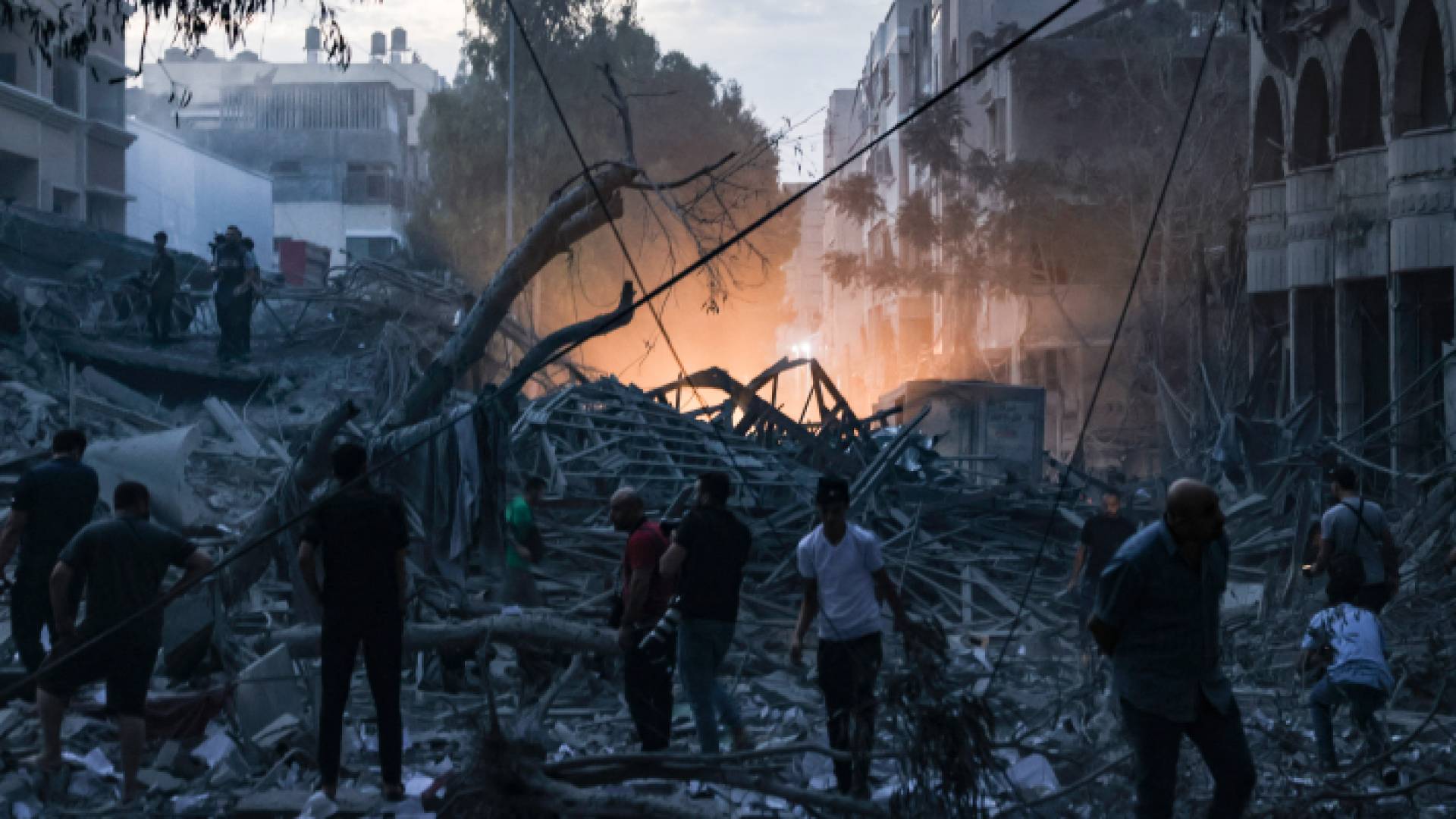 فلسطينيون فوق أنقاض برج تم تدميره في غارة جوية