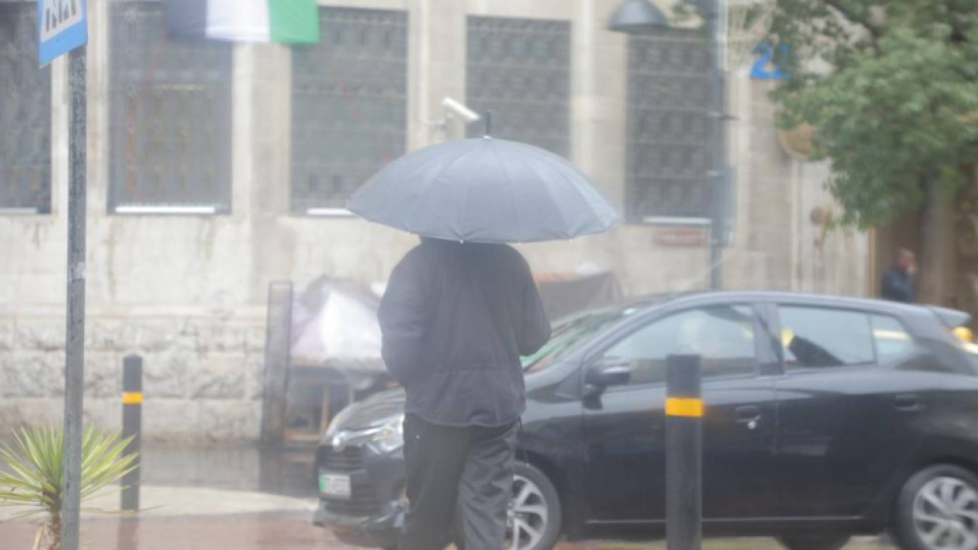 شخص يحمل مظلة في أحد شورع العاصمة عمان