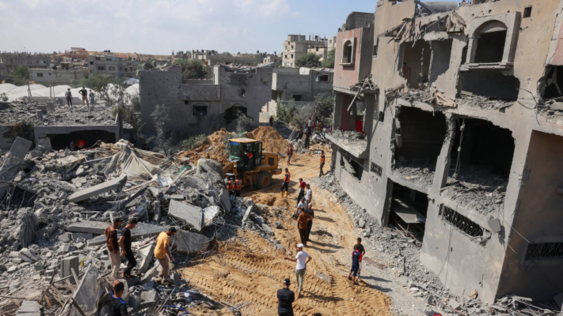 فرق الإنقاذ الفلسطينية تبحث تحت أنقاض المباني المدمرة جراء ضربة إسرائيلية.