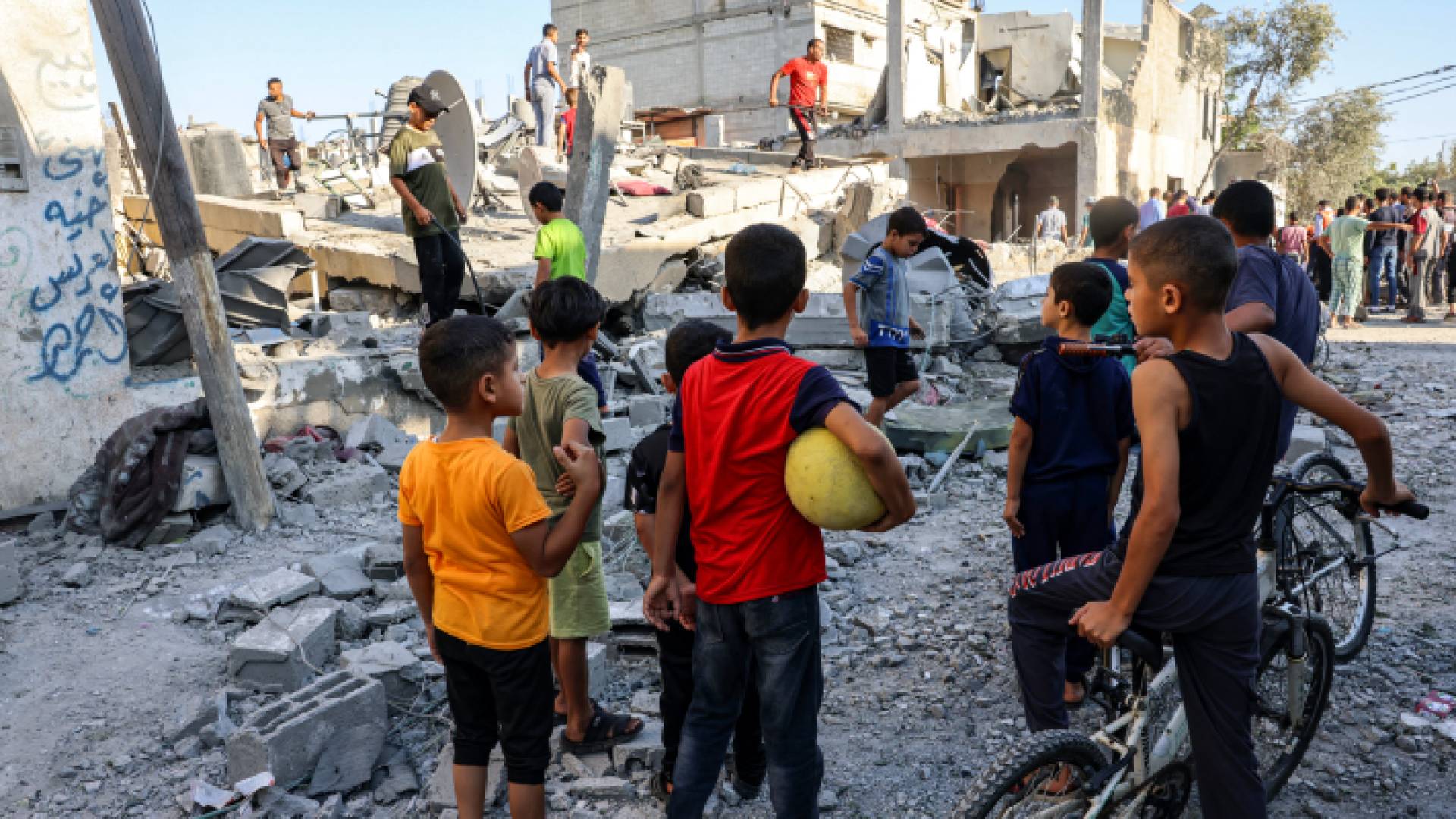 أطفال يقفون أمام أنقاض أحد المنازل التي تعرضت للدمار نتجة قصف الاحتلال