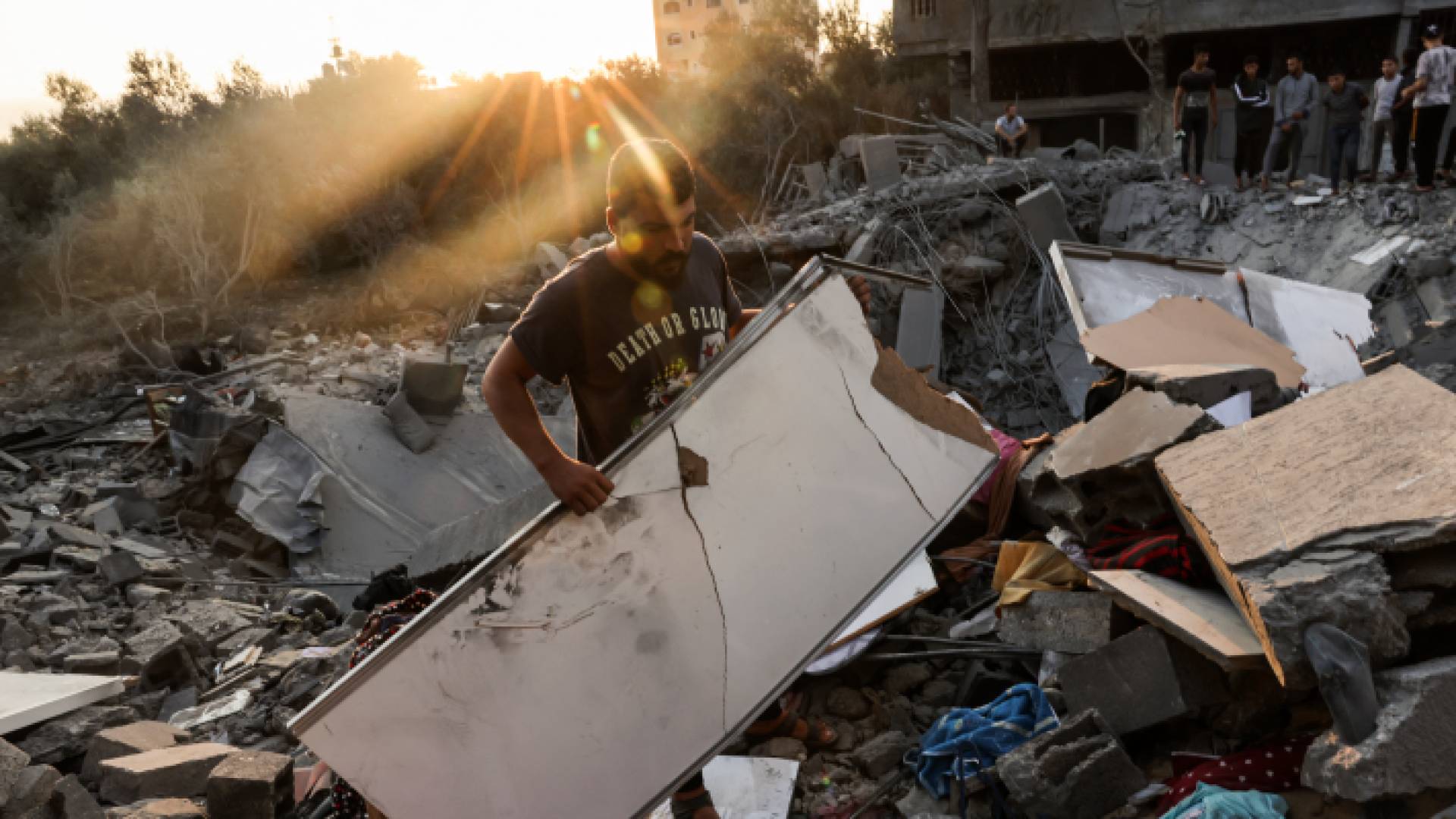 فلسطيني يحمل آثار دمار قصف الاحتلال الإسرائيلي على قطاع غزة