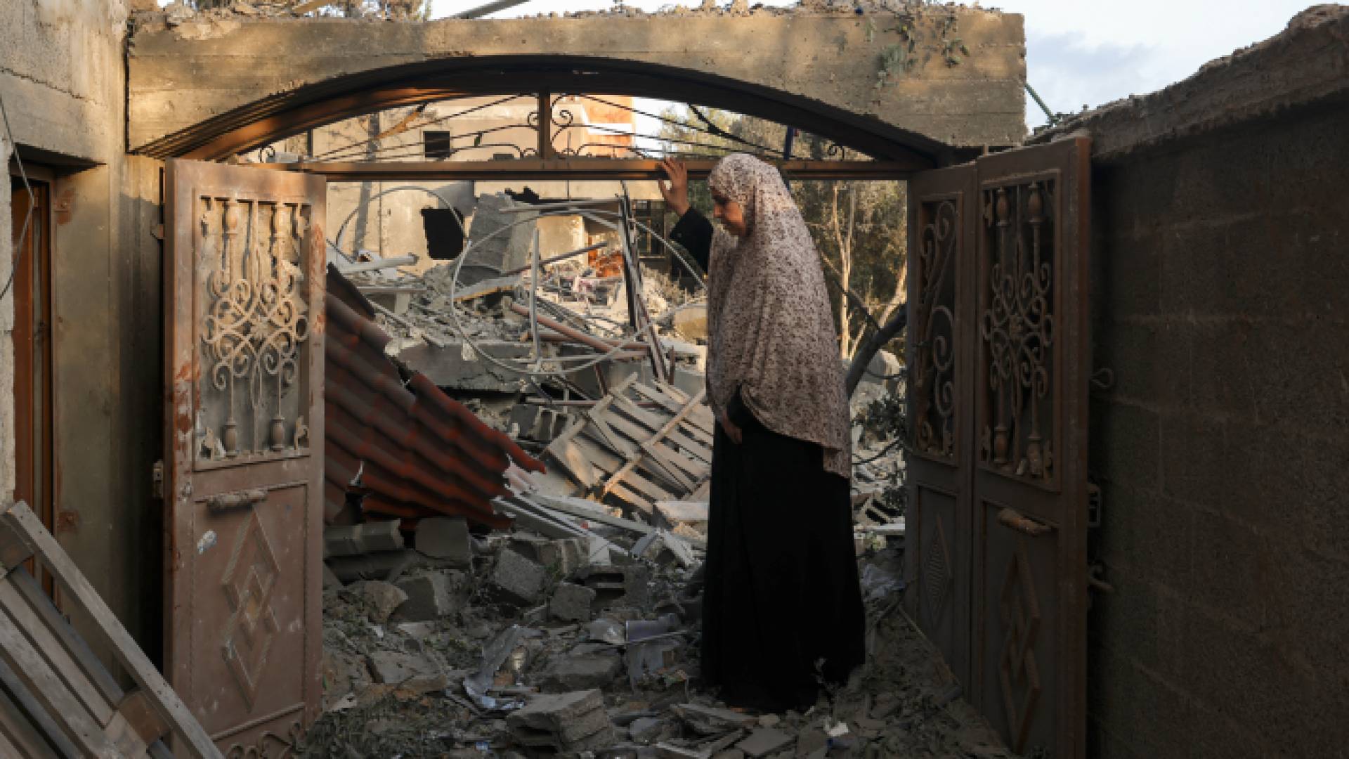 مسنة تقف فوق منزلها المدمر