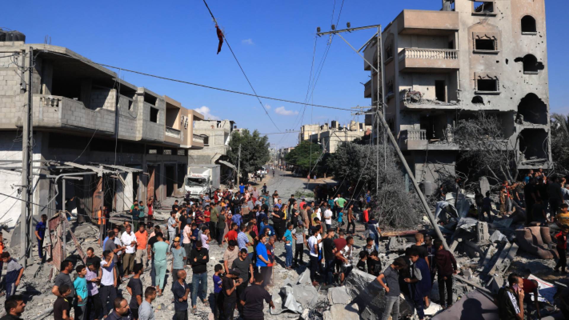 لفلسطينيون يتجمعون على موقع المباني المنهارة والمتضررة جراء غارات الاحتلال التي استهدفت رفح