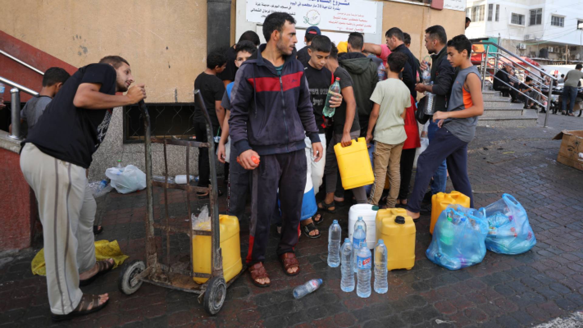 فلسطينيون يصطفون لملء أوعية المياه في مدينة غزة