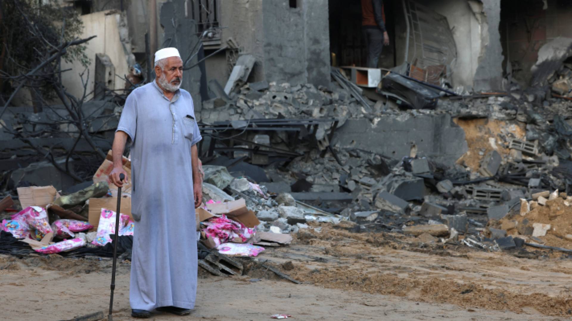 فلسطيني يقف أمام منزل مدمر في قطاع غزة