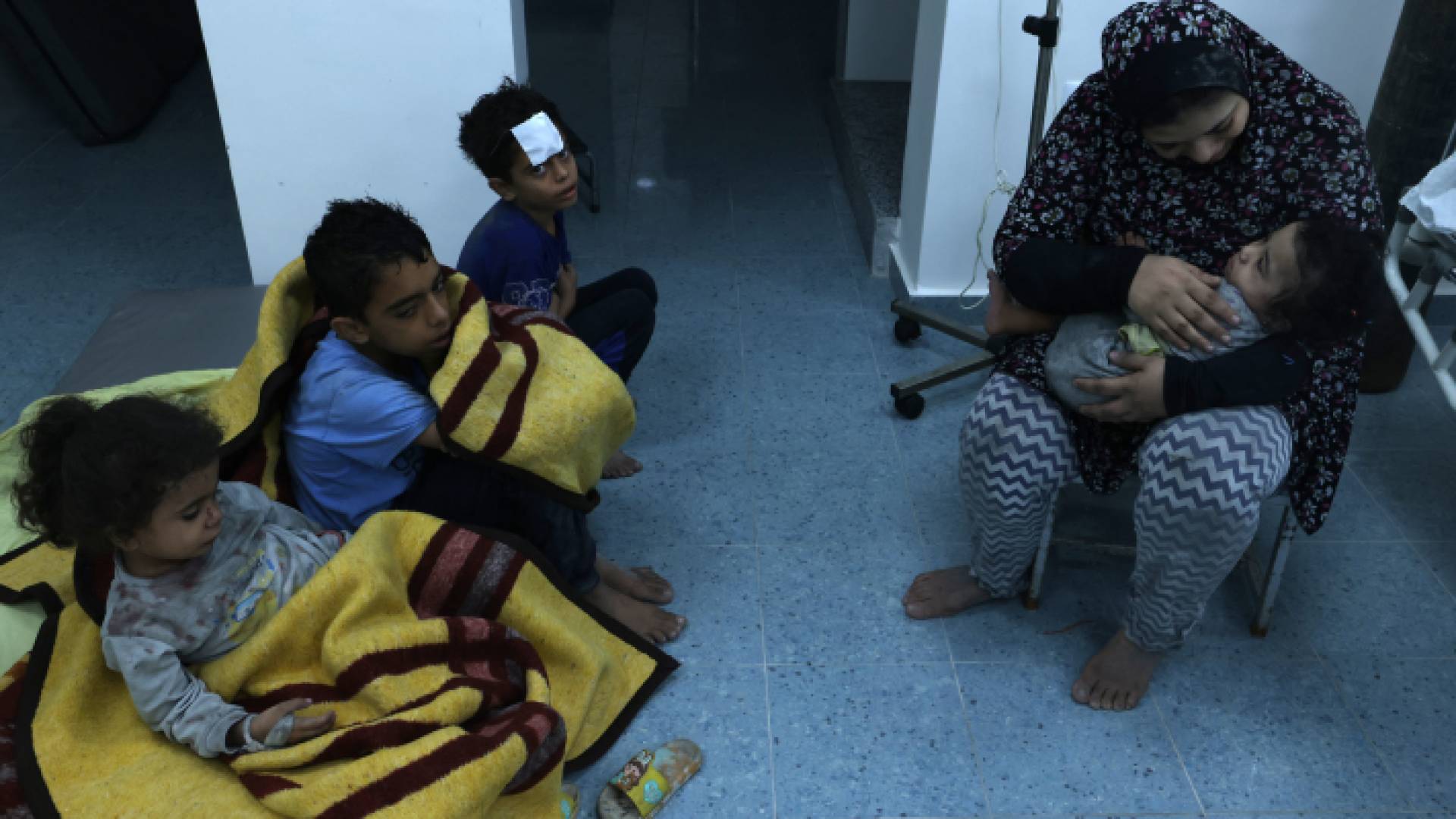 فلسطينية تعتني بأبنائها في أحد المستشفيات في قطاع غزة