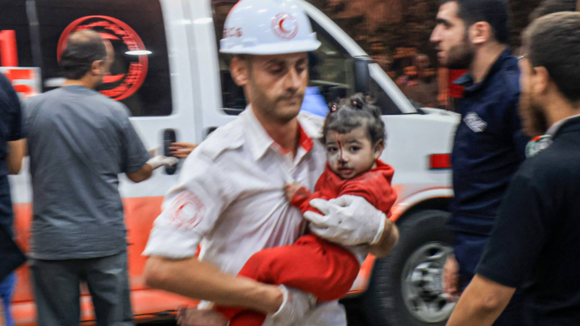 مسعف يحمل طفلة بعد إصابتها بقصف الاحتلال لمستشفى المعمدانية