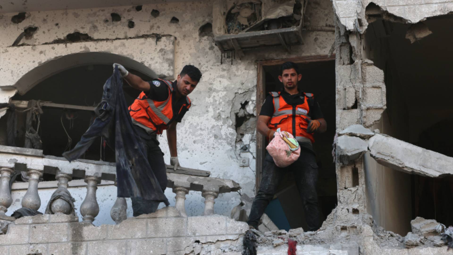 مسعفان داخل أحد المنازل التي تعرضت للقصف في غزة