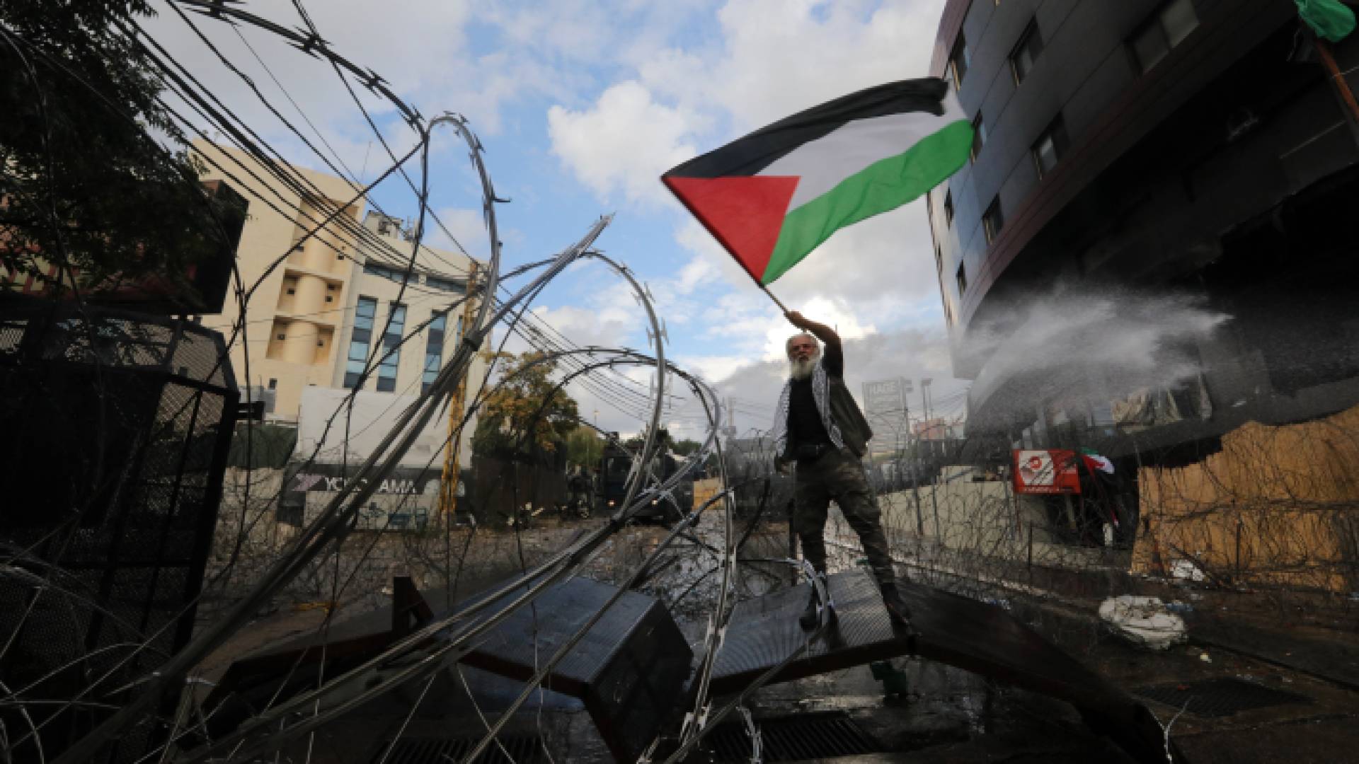 لبناني يحمل العلم الفلسطيني بمحيط السفارة الأمريكية في بيروت