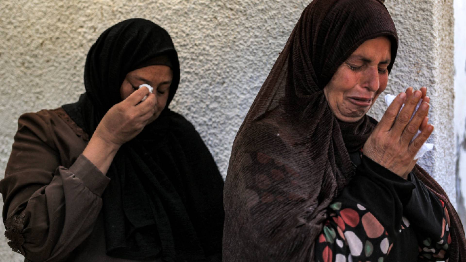 فلسطينيتان تبكيان حزنا على شهداء مجزرة مستشفى المعمداني