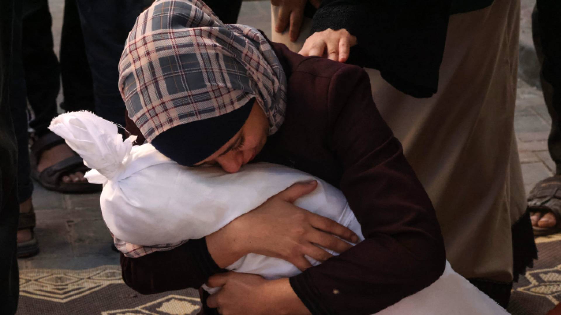 فلسطينية تحتضن طفلها الذي فقدته في قصف للاحتلال الإسرائيلي على قطاع غزة