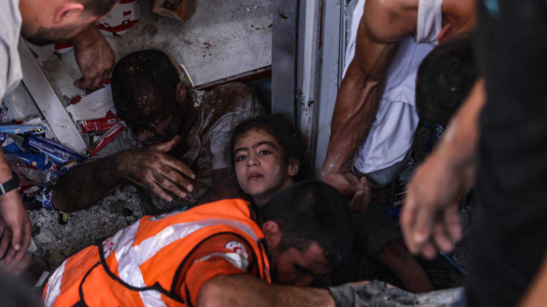 مسعفون يسحبون فتاة صغيرة مصابة ورجلا من تحت أنقاض مبنى ضربته غارة للاحتلال في مخيم رفح بقطاع غزة