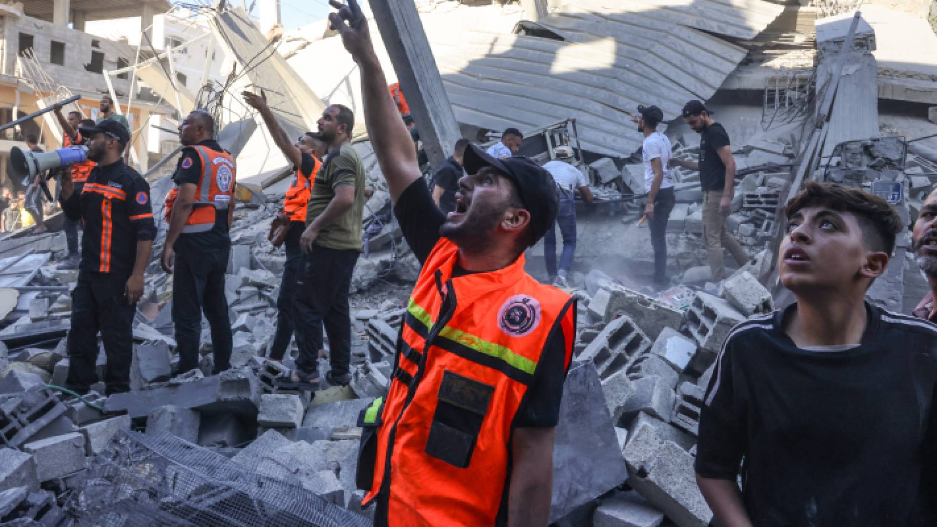 فلسطينيون بعد غارة جوية استهدفت مبان في القطاع