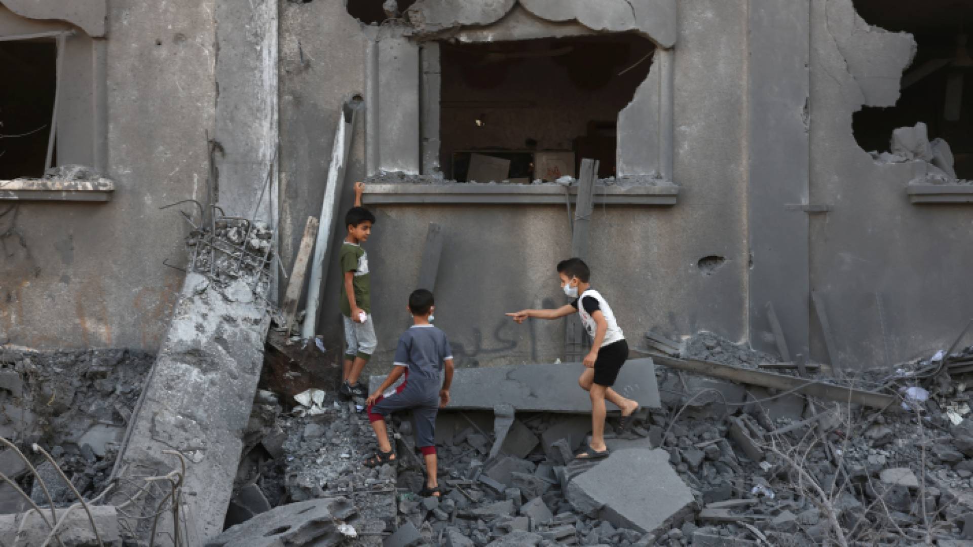 أطفال يلعبون بالقرب من أحد المنازل التي تعرضت لقصف الاحتلال في غزة