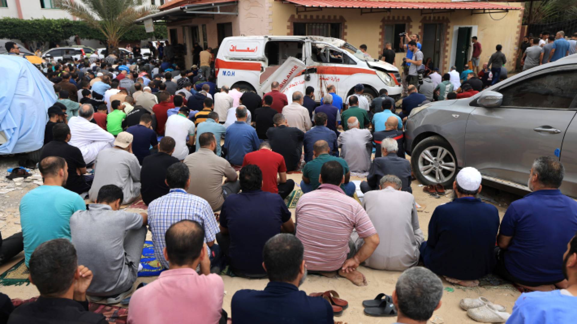 فلسطينوين أمام أحد مستشفيات قطاع غزة