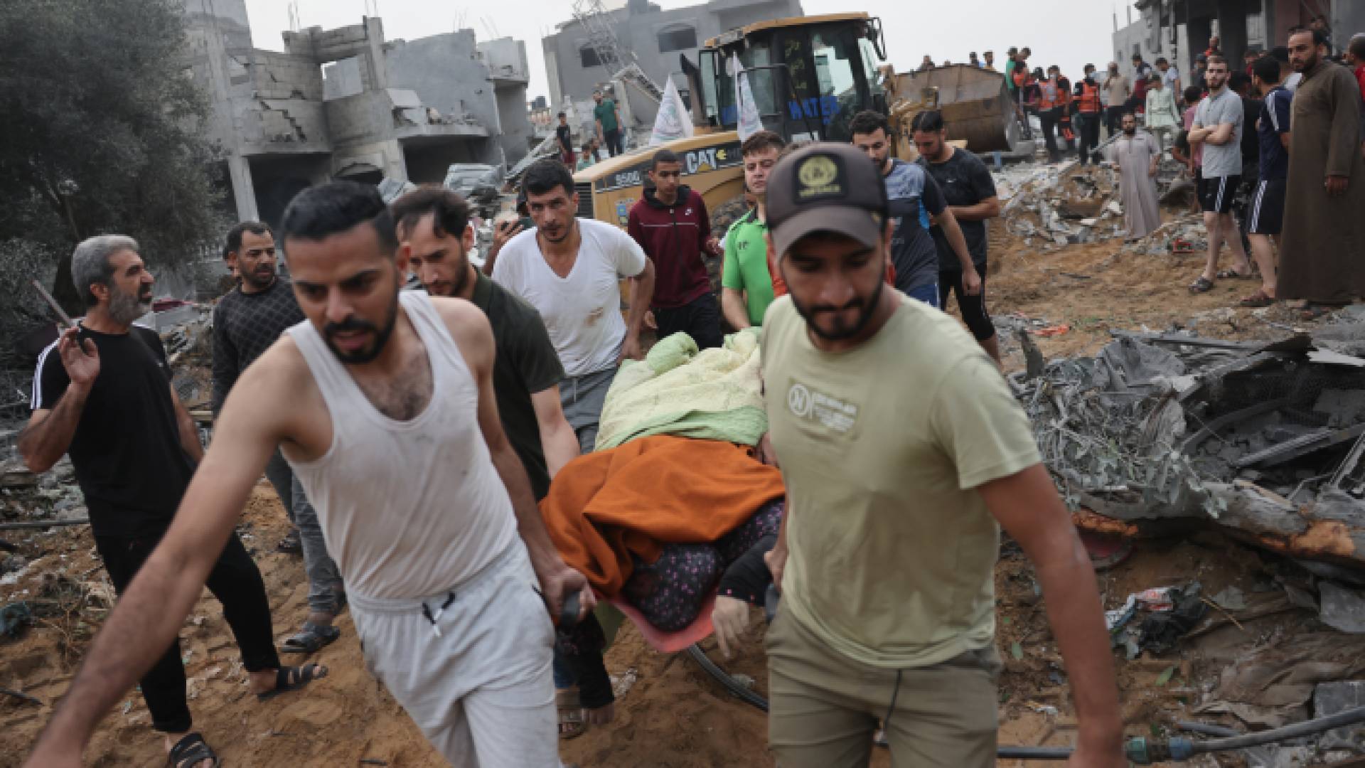 فلسطينيان ينقلان أحد الشهداء جراء قصف الاحتلال الإسرائيلي على القطاع