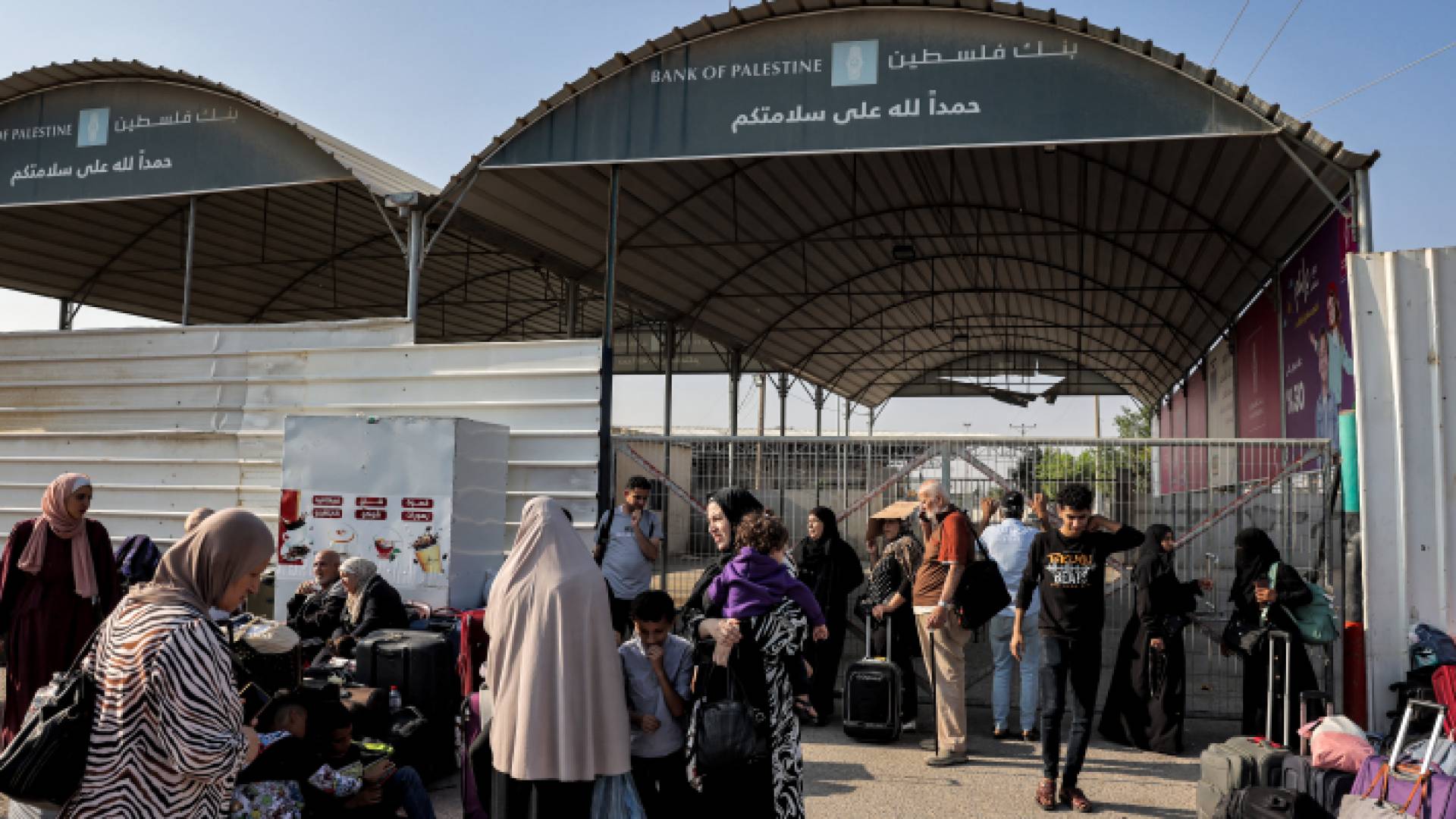 أشخاص ينتظرون عند معبر رفح الحدودي مع مصر في جنوب قطاع غزة