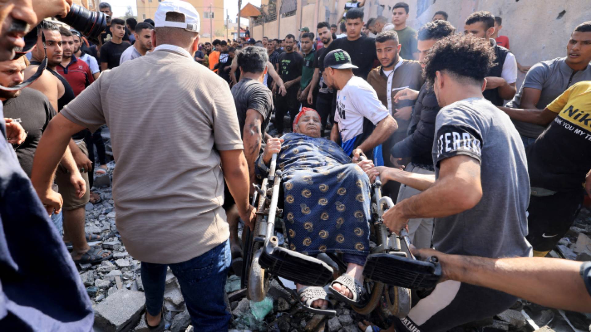 فلسطينيون ينقلون سيدة أصيبت بقصف الاحتلال الإسرائيلي على قطاع غزة