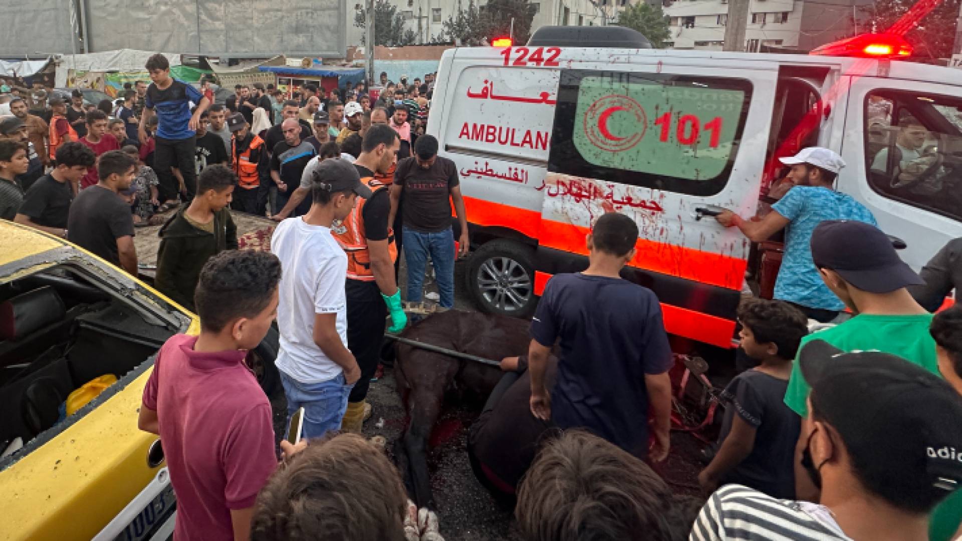 فلسطينيون يتجمهرون حول مركبة إسعاف عقب قصفها من قبل الاحتلال الإسرائيلي