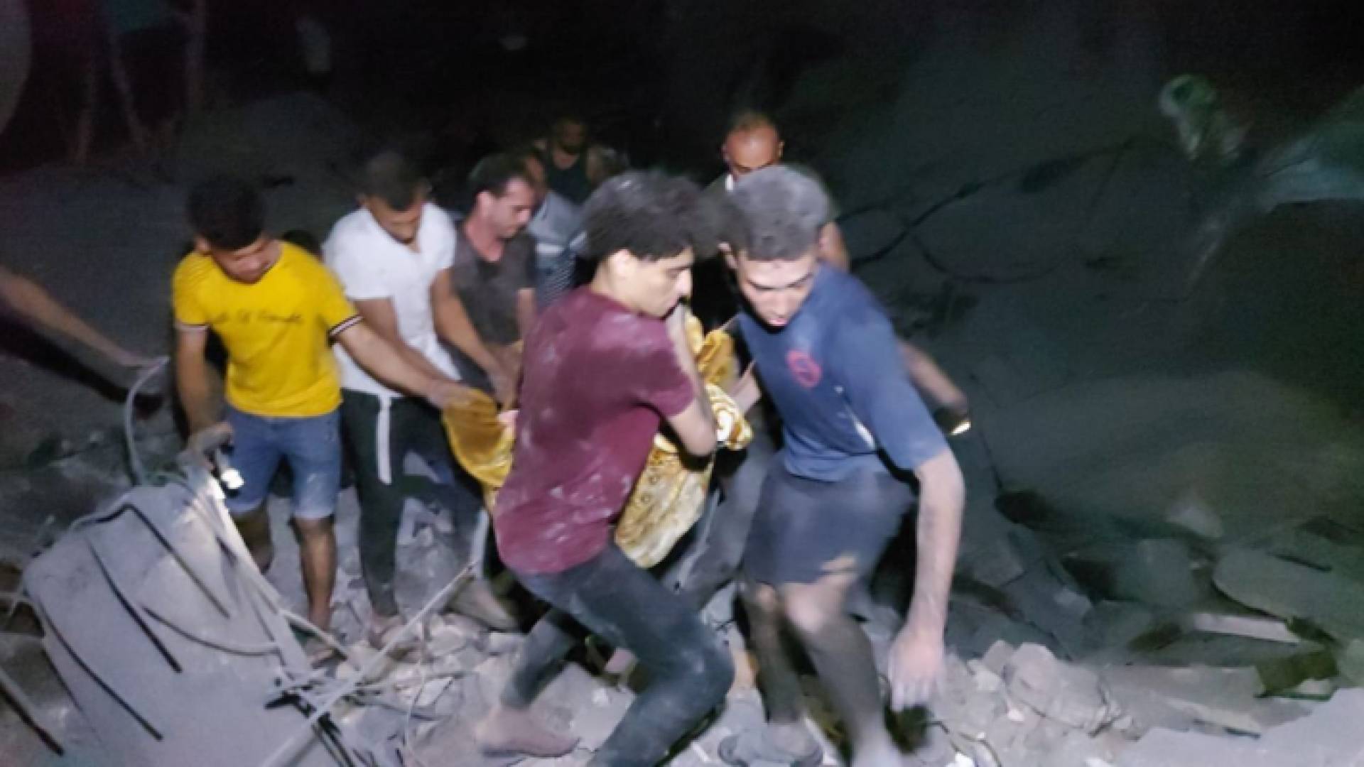 فلسطينيون ينتشلون أحد الشهداء من مخيم المغازي