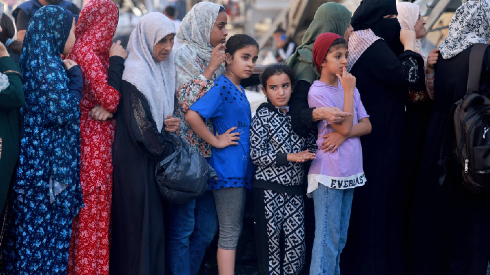 فلسطينيون يقفزن في طابور للحصول على الطعام والمياه