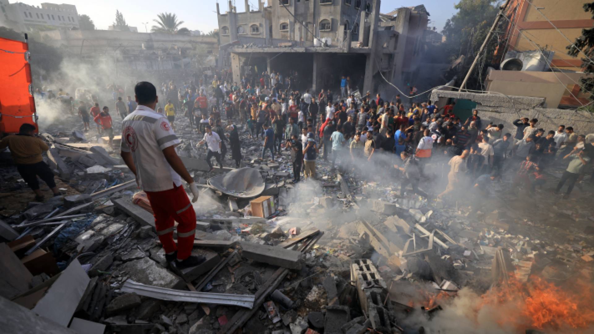 فلسطينيون بالقرب من أحد المنازل التي دمرت بقصف الاحتلال