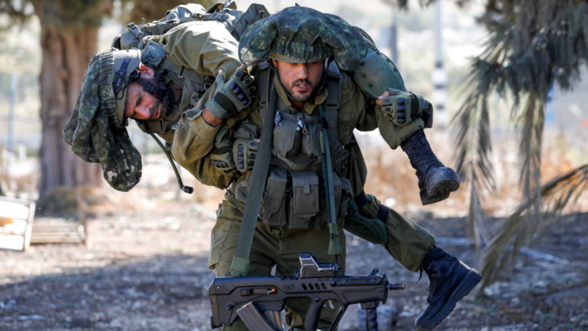 جندي من قوات الاحتلال يحمل زميله الذي أصيب في استهداف من قبل حزب الله