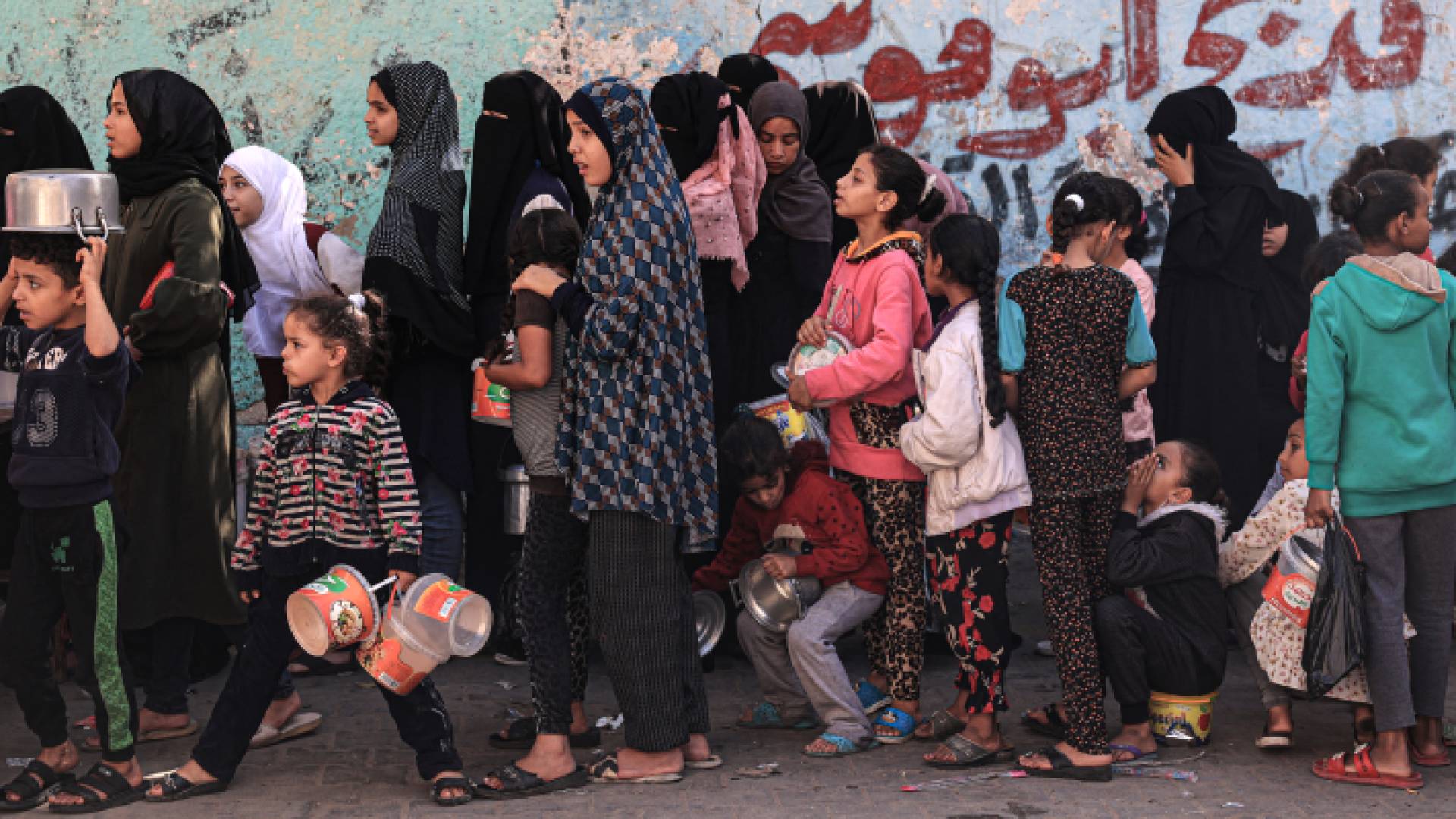 فلسطينيات يقفن في طابور ينتظرن دورهن للحصول على الطعام في غزة