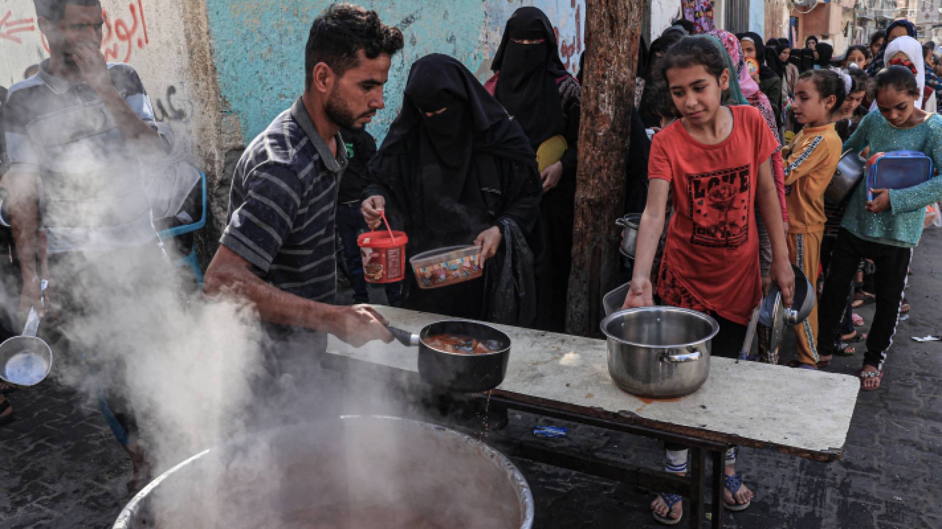 فلسطينيون يقفون في طابور بانتظار حصولهم على طعام في قطاع غزة