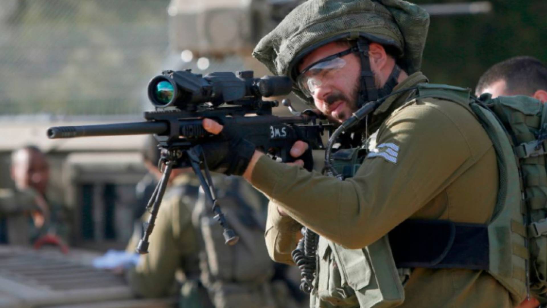 عنصر من قوات الاحتلال يصوب سلاحه نحو فلسطينين