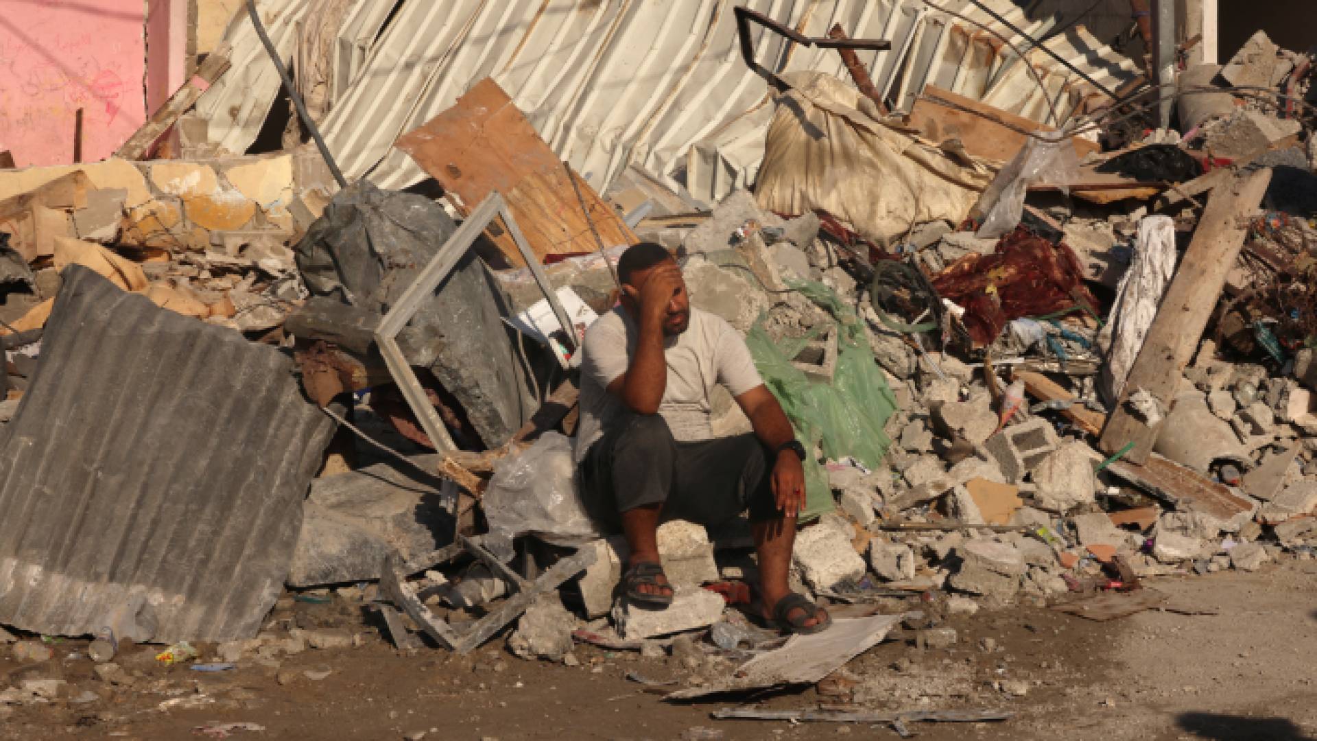 فلسطيني يجلس فوق آثار دمار منزله في غزة