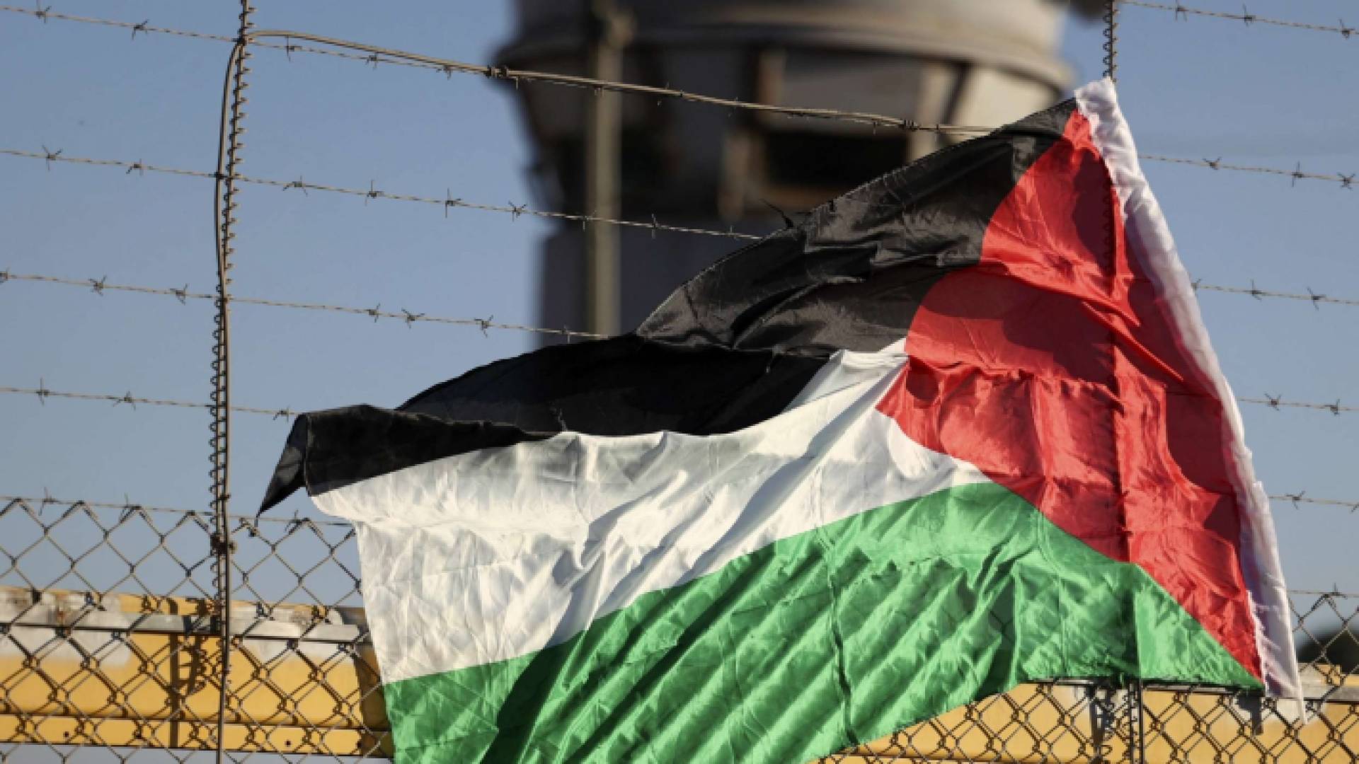 علم فلسطين أمام سجن للاحتلال