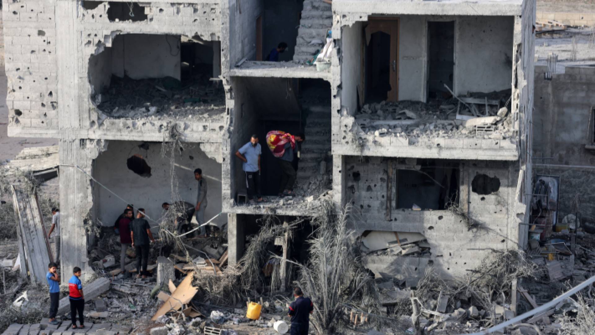 فلسطينيون عقب استهداف عمارة في غزة