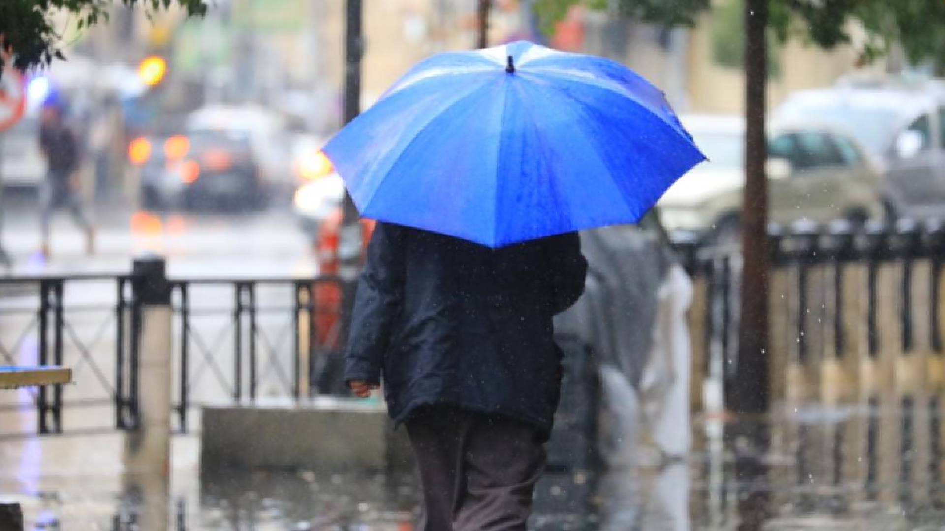 شخص يحمل مظلة في أحد شورع العاصمة عمان