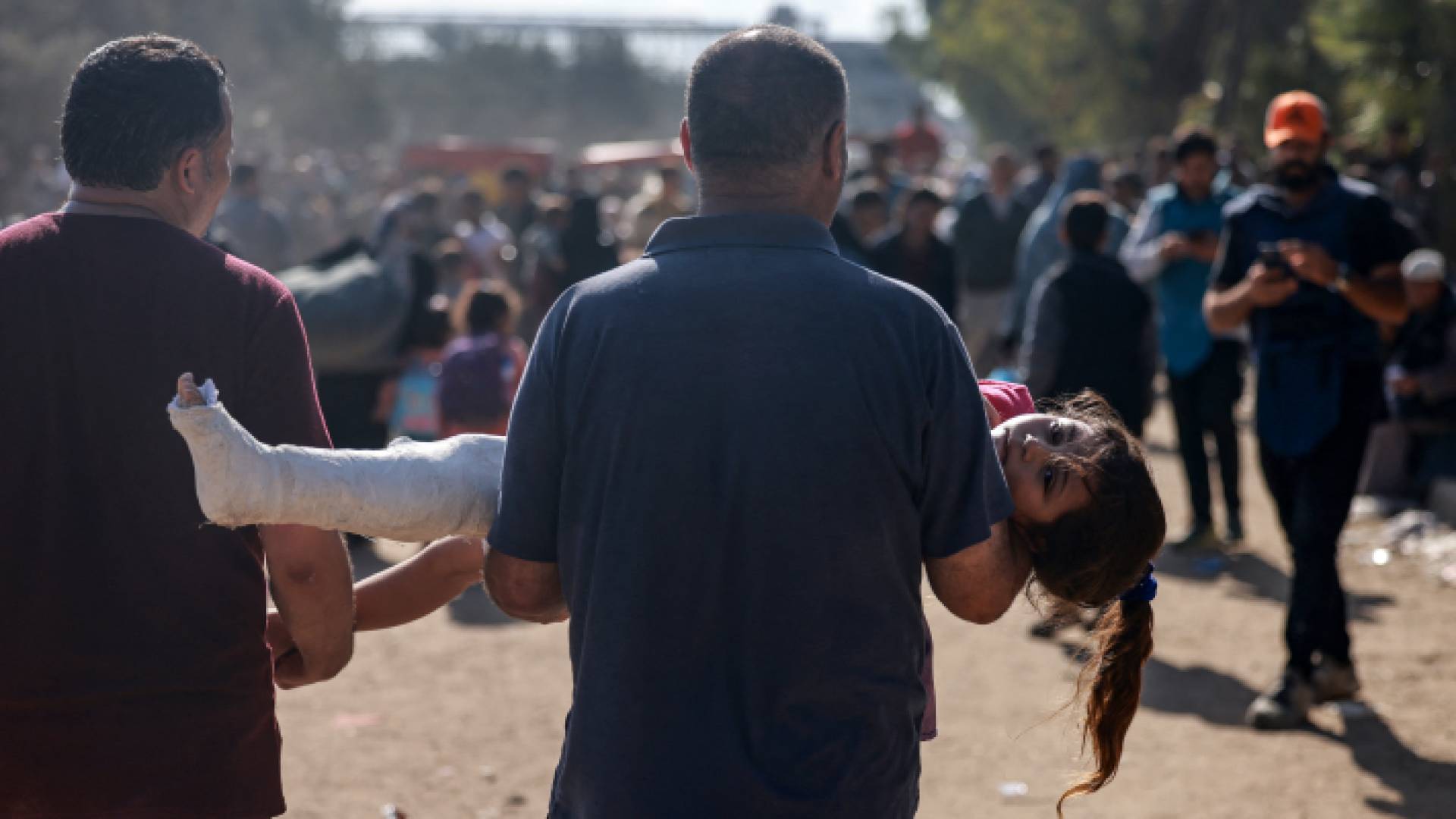 رجل يحمل طفلة مصابة من قصف الاحتلال