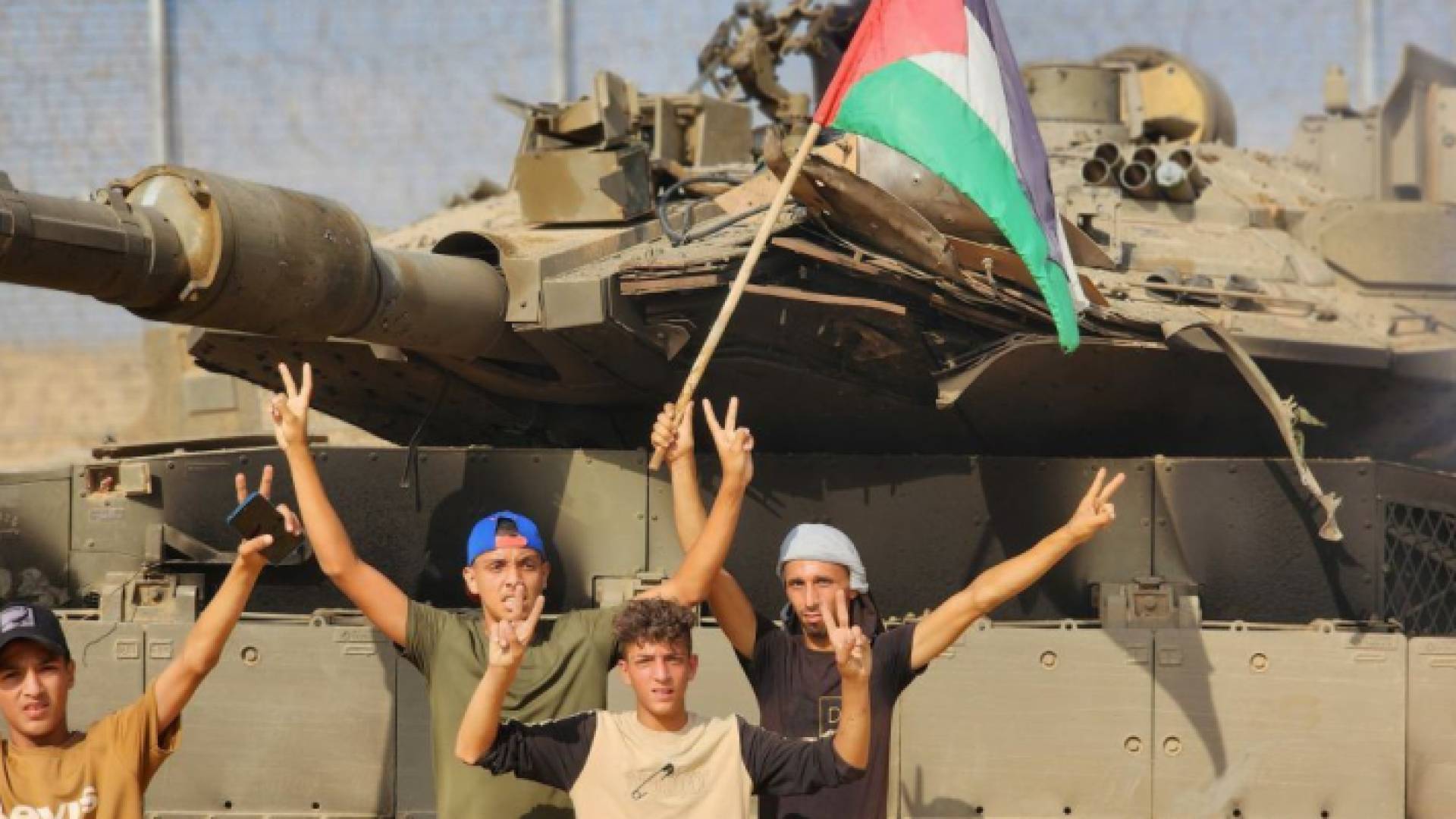 رفع علم فلسطين أمام دبابة الاحتلال المدمرة