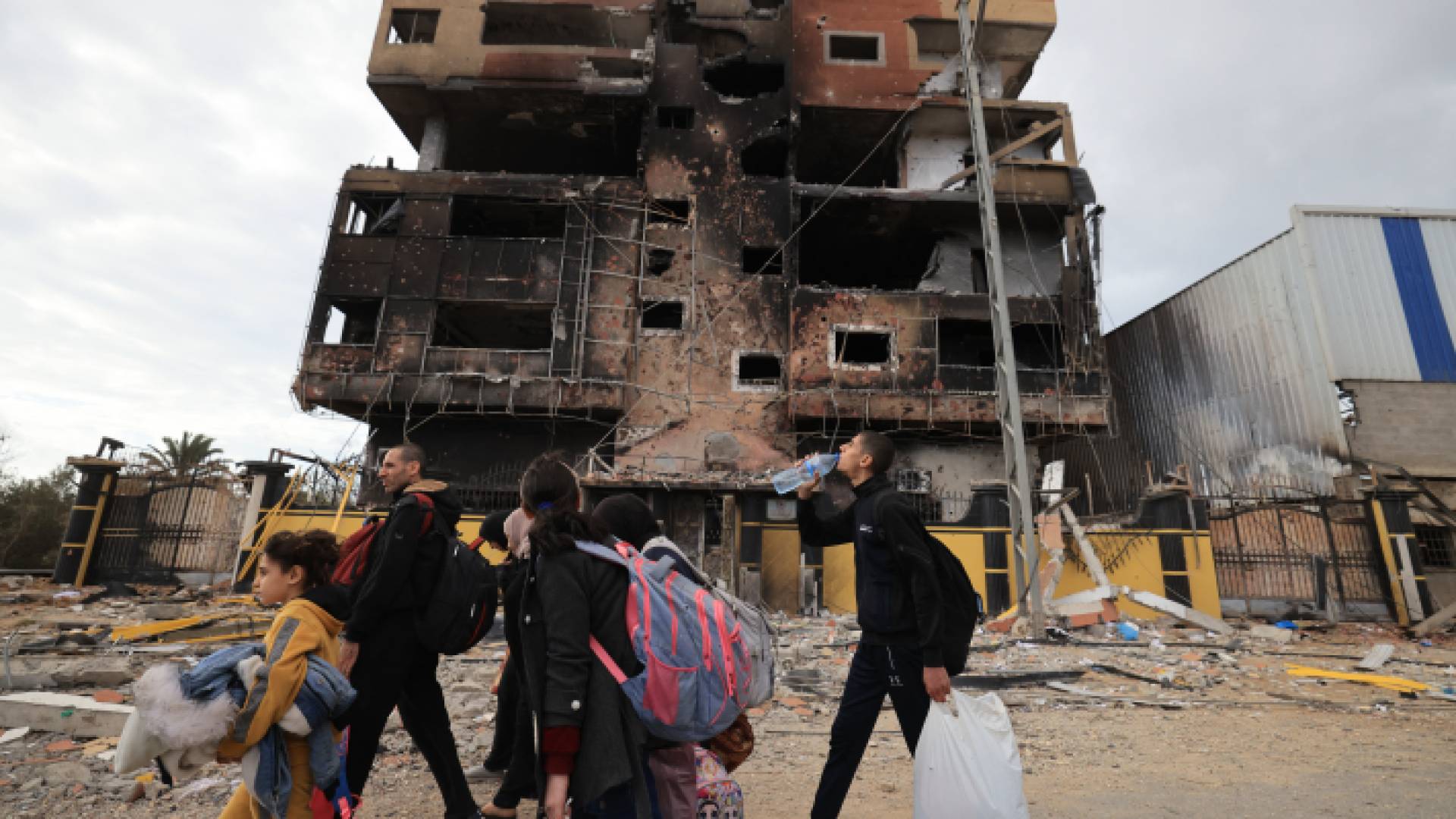 فلسطينيون أمام منزل تطعرض للقصف في غزة