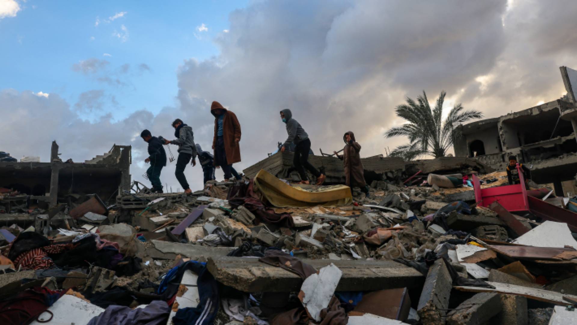 فلسطينيون فوق أنقاض منزلهم المدمر جراء استهداف الاحتلال