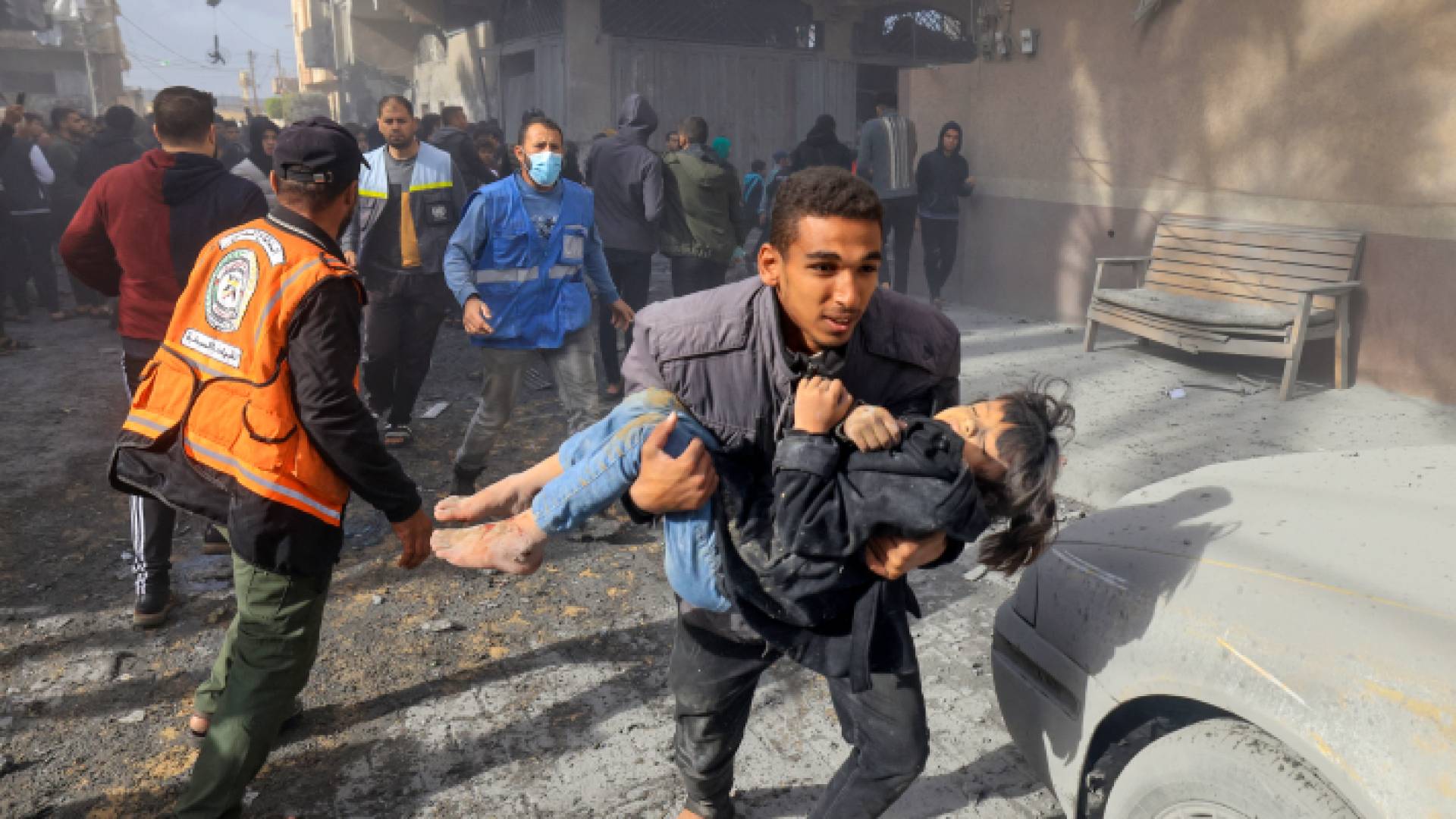 فلسطيني يحمل طفلة رجل يحمل طفلا أصيب في غارة للاحتلال على رفح في جنوب قطاع غزة