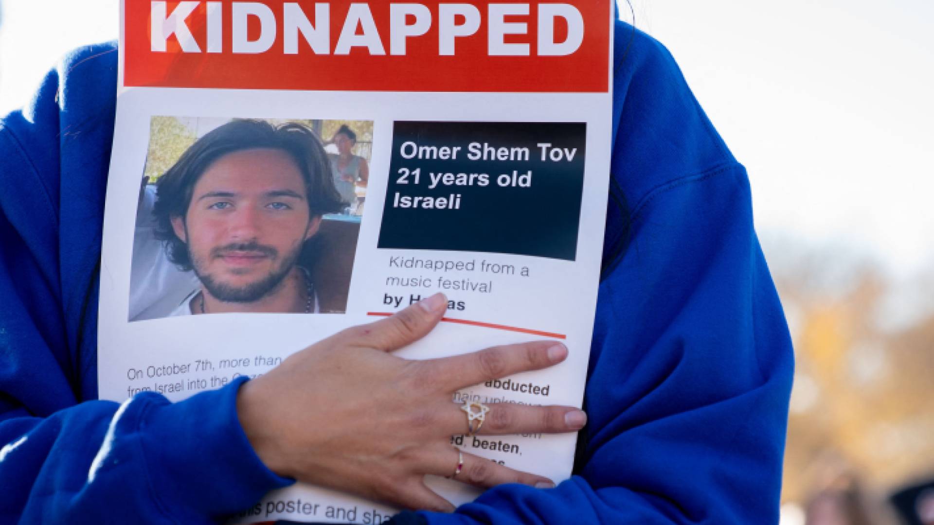 مستوطنة تحمل صورة أحد المحتجزين في قطاع غزة